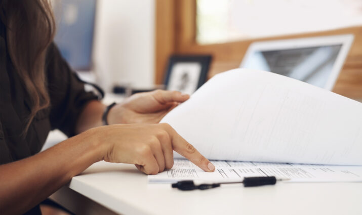 Closeup shot of an unrecognisable businesswoman going through paperwork in an office