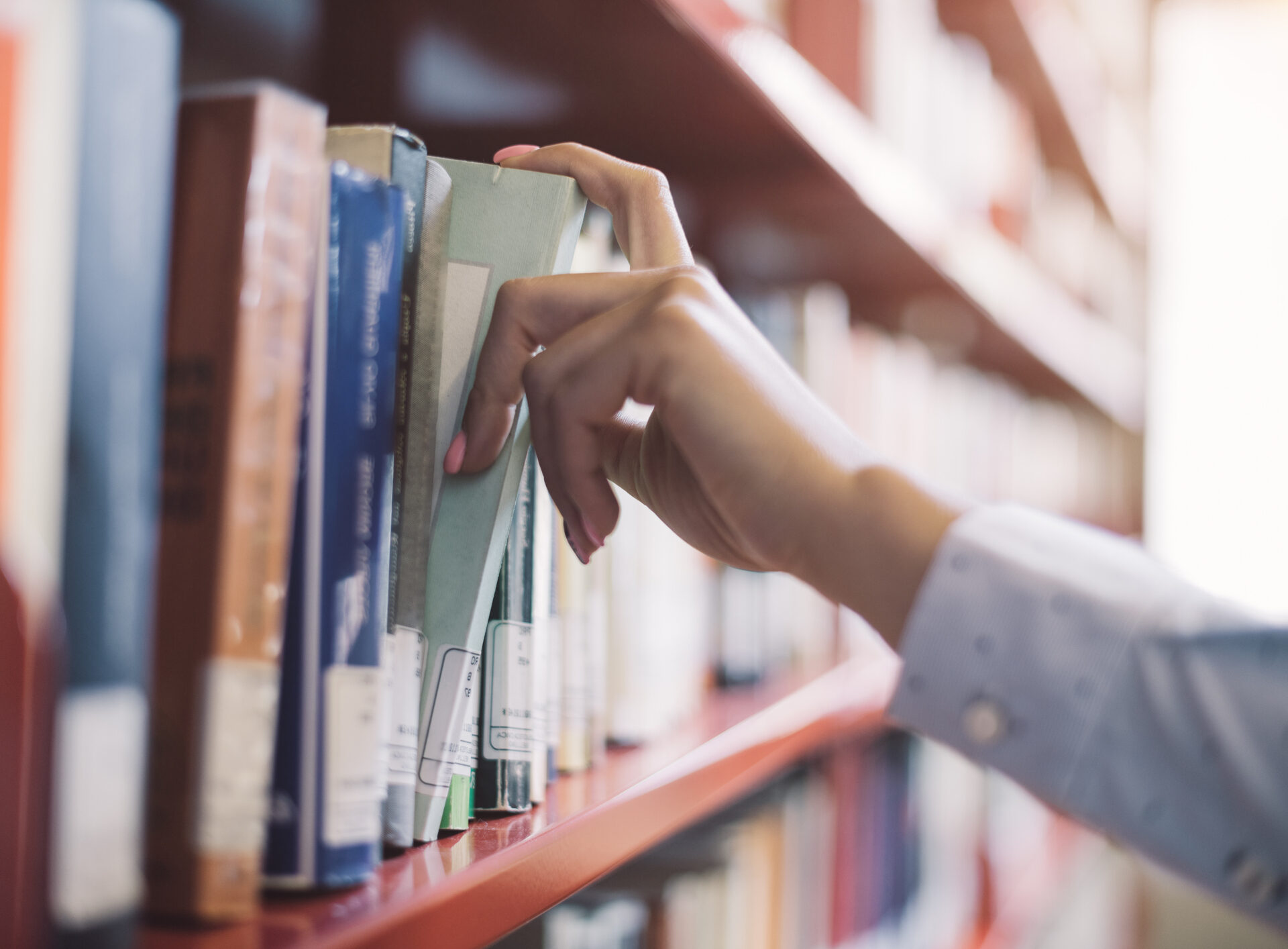 hand taking book off shelf