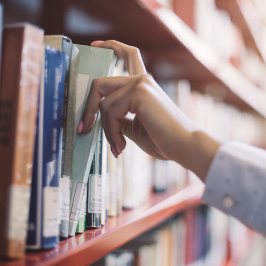 hand taking book off shelf