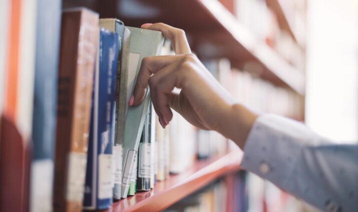 hand taking book off shelf