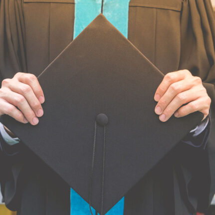 commencement, student holding mortar board