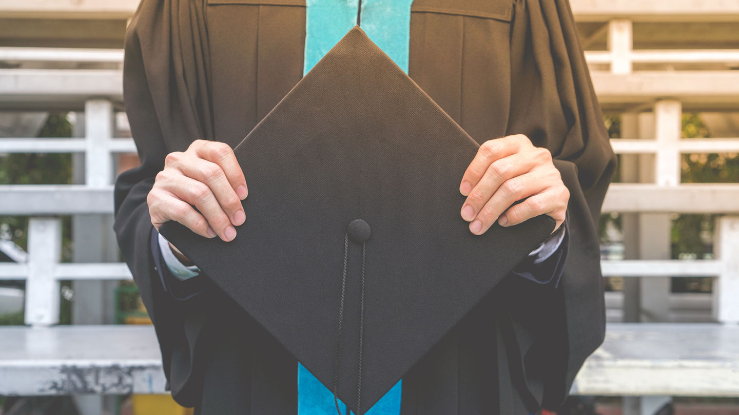 commencement, student holding mortar board