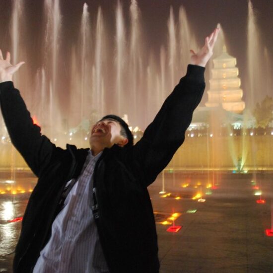 male celebrating with arms in the air