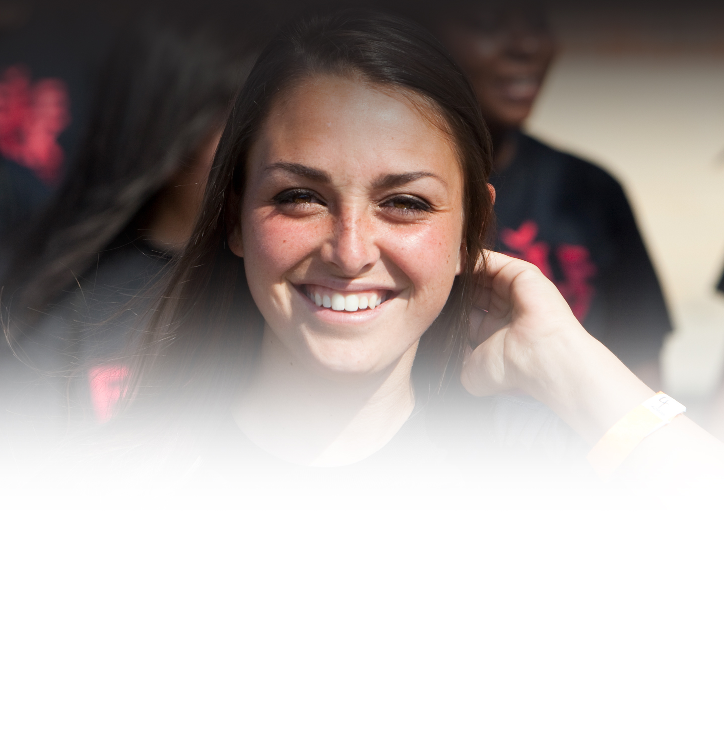 head-shot of female Benedictine Student smiling holding her hair back. image has white overlay on the bottom