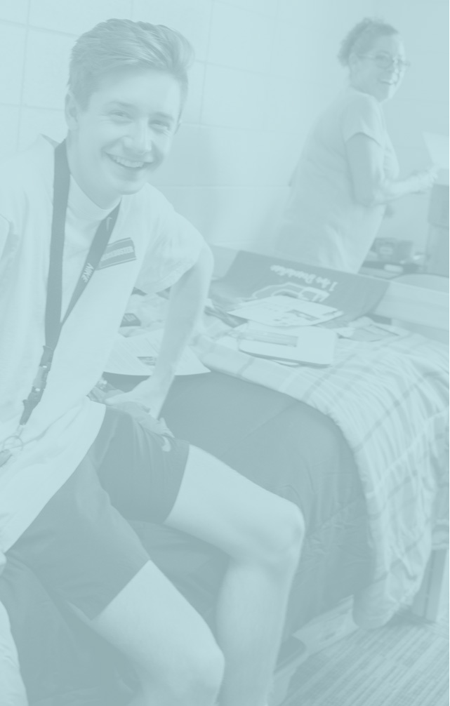male student with his mother moving into a dorm room on campus; image has a blue overlay