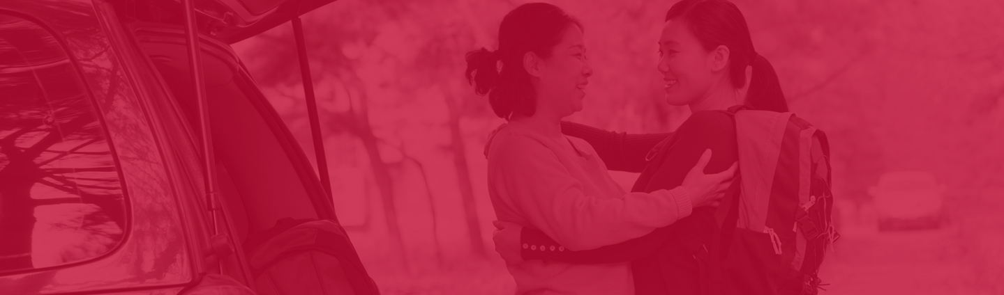 two female students greeting each other, image has a red overlay on it