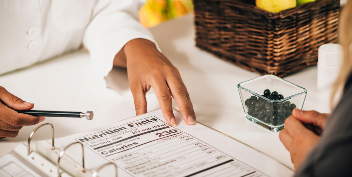 hands pointing to a notebook with nutrition facts written out on the page; nutrition and dietetics ms program