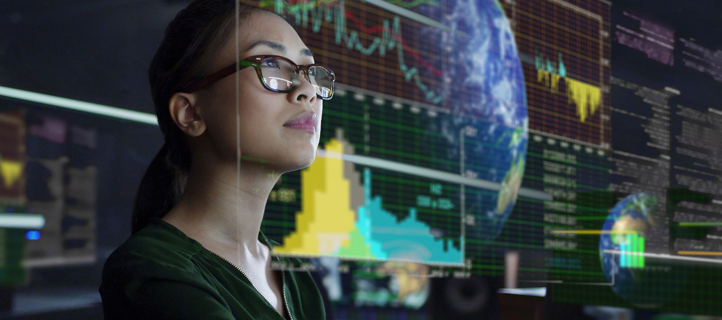 woman looking off with business graphics in the reflection of the glass in front of her; business analytics ms