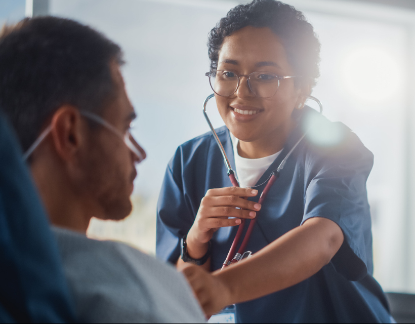 female pre-professional student with stethoscope examining patient; pre-medicine