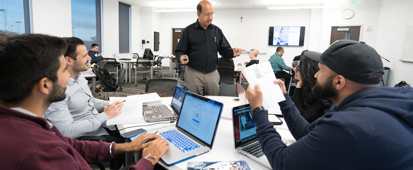 group of adults students in a study group with their instructor discussing material
