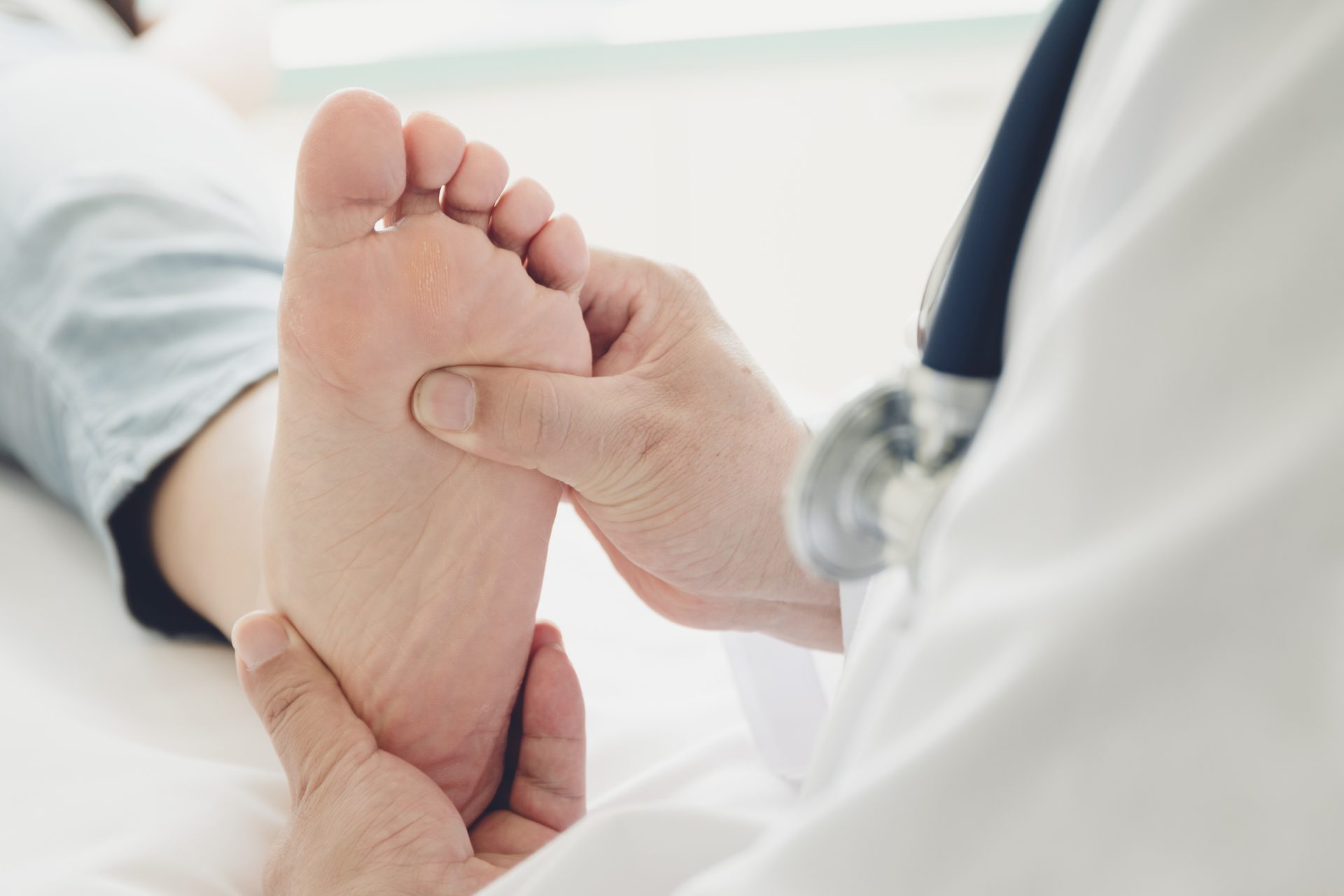 podiatrist holding patient's foot while pushing his thumb into the ball of foot; Pre-Podiatry