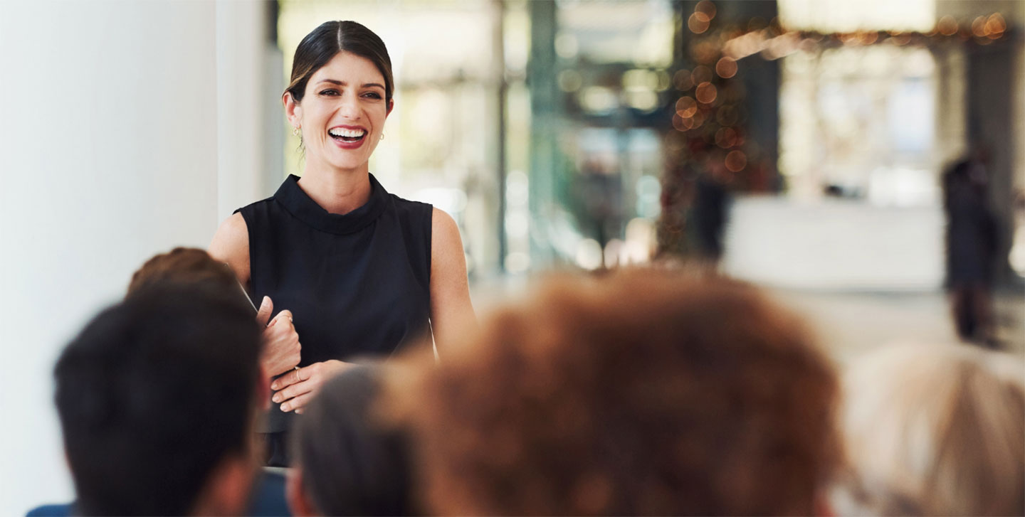 female student at the front of a class giving presentation; Business Analytics program
