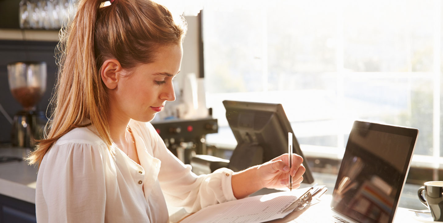 Female student writing on a clipboard ; management program
