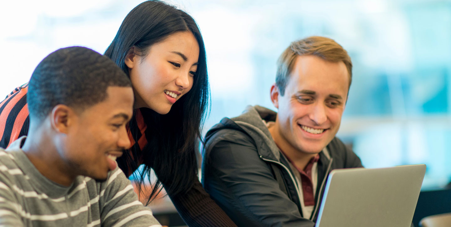 three student looking at a laptop screen; management and organizational behavior
