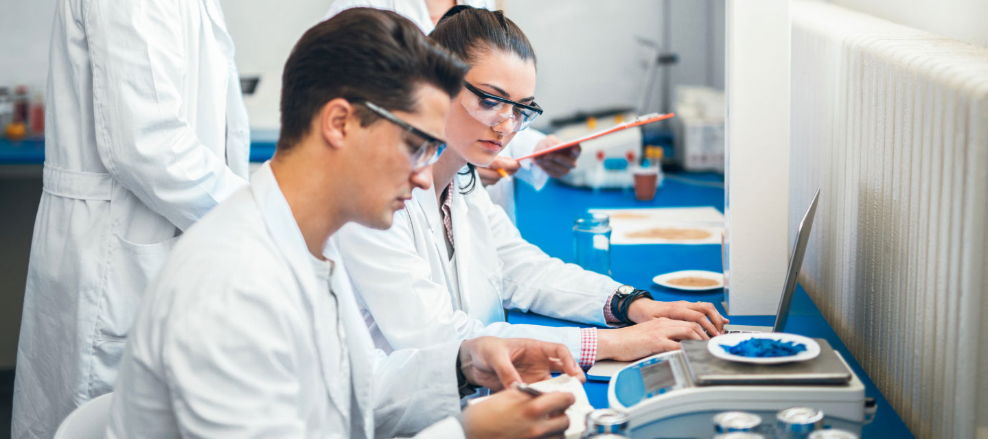 students in laboratory weighing specimen; environmental science
