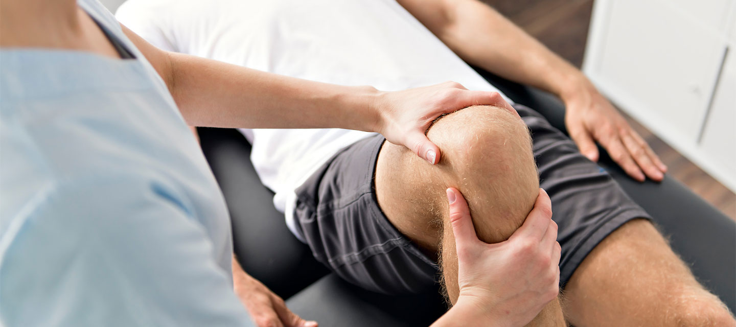 therapist working on a knee; sport and exercise science