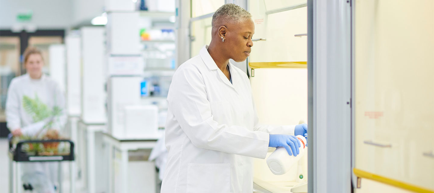 female working under the hood in a lab setting; biochemistry, molecular biology