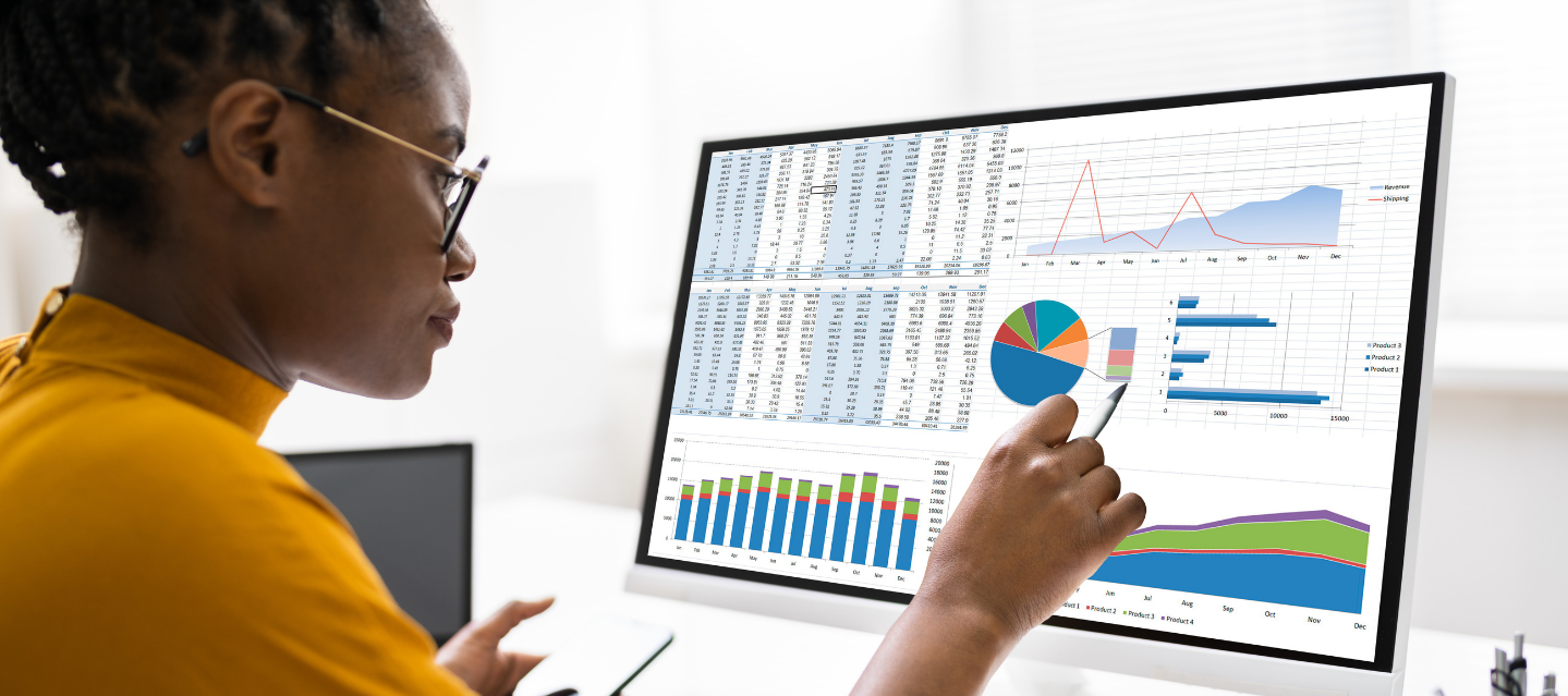 female student pointing to chart on her computer screen; business analytics