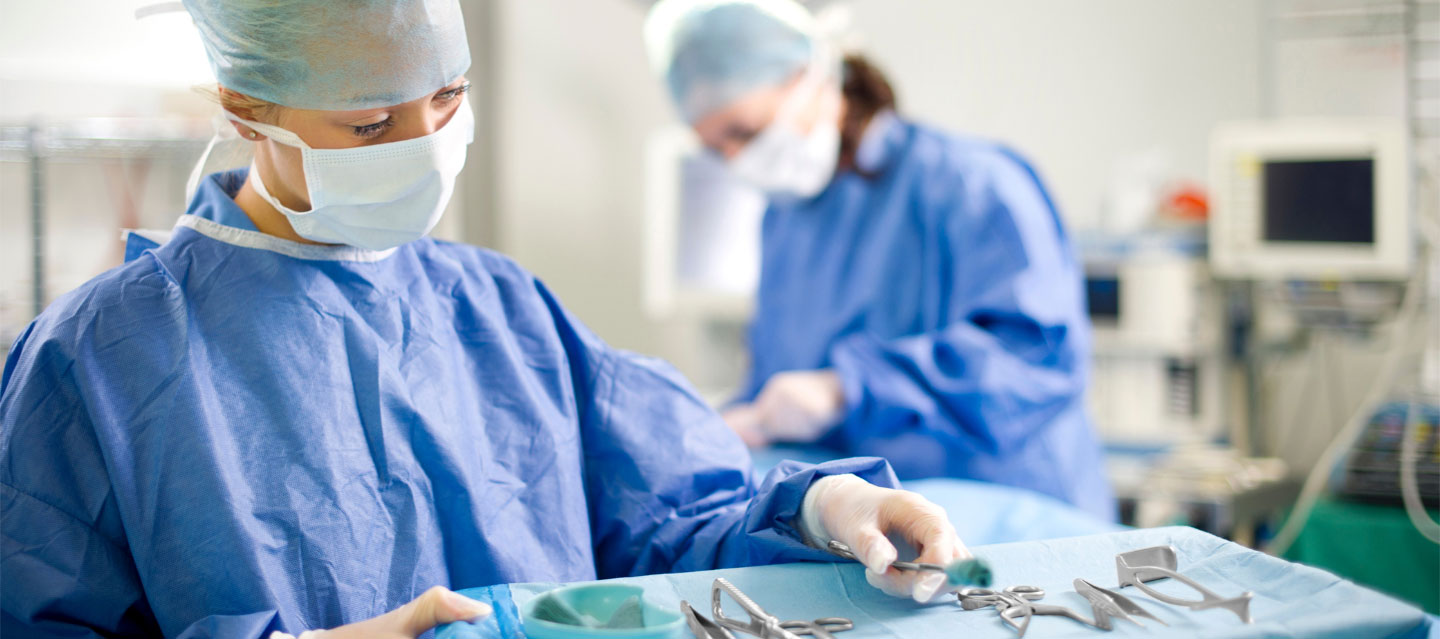 nurses in scrubs and masks working with surgical tools