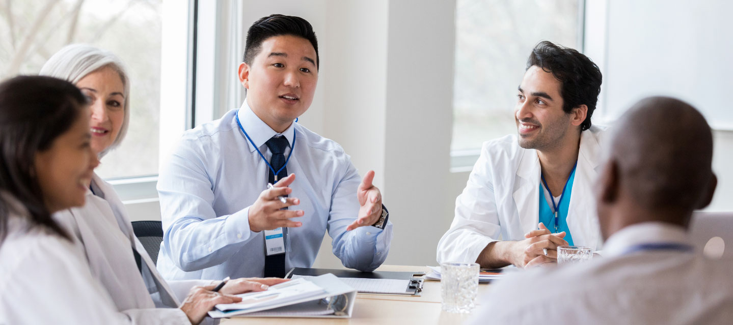 group of medical professionals at the table in a discussion; public health