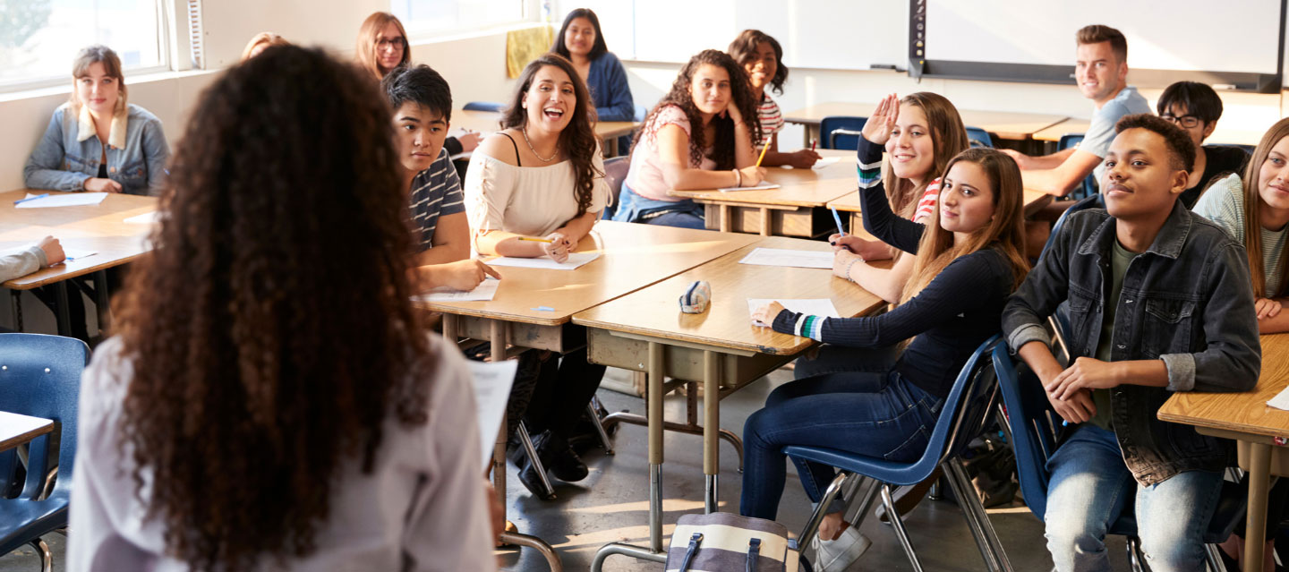 teacher standing in front of high school class; secondary education