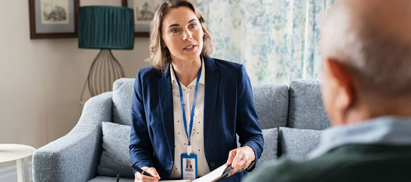 female counselor speaking with older male patient; sociology