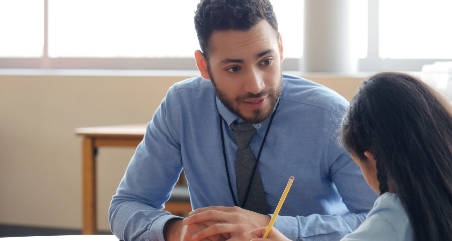 male student helping an elementary student with an assignment; Elementary education program