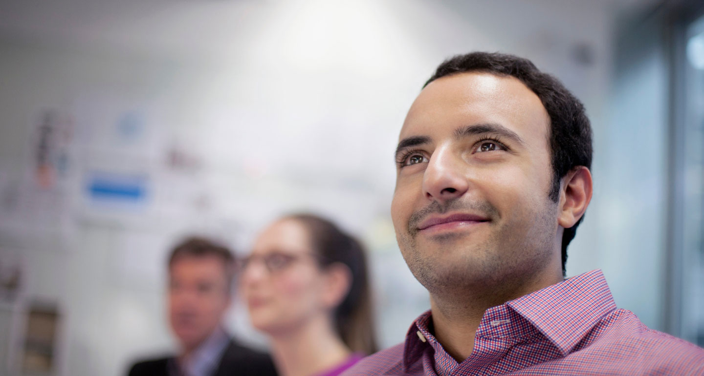 headshot of male student smiling while looking on in class; finance program