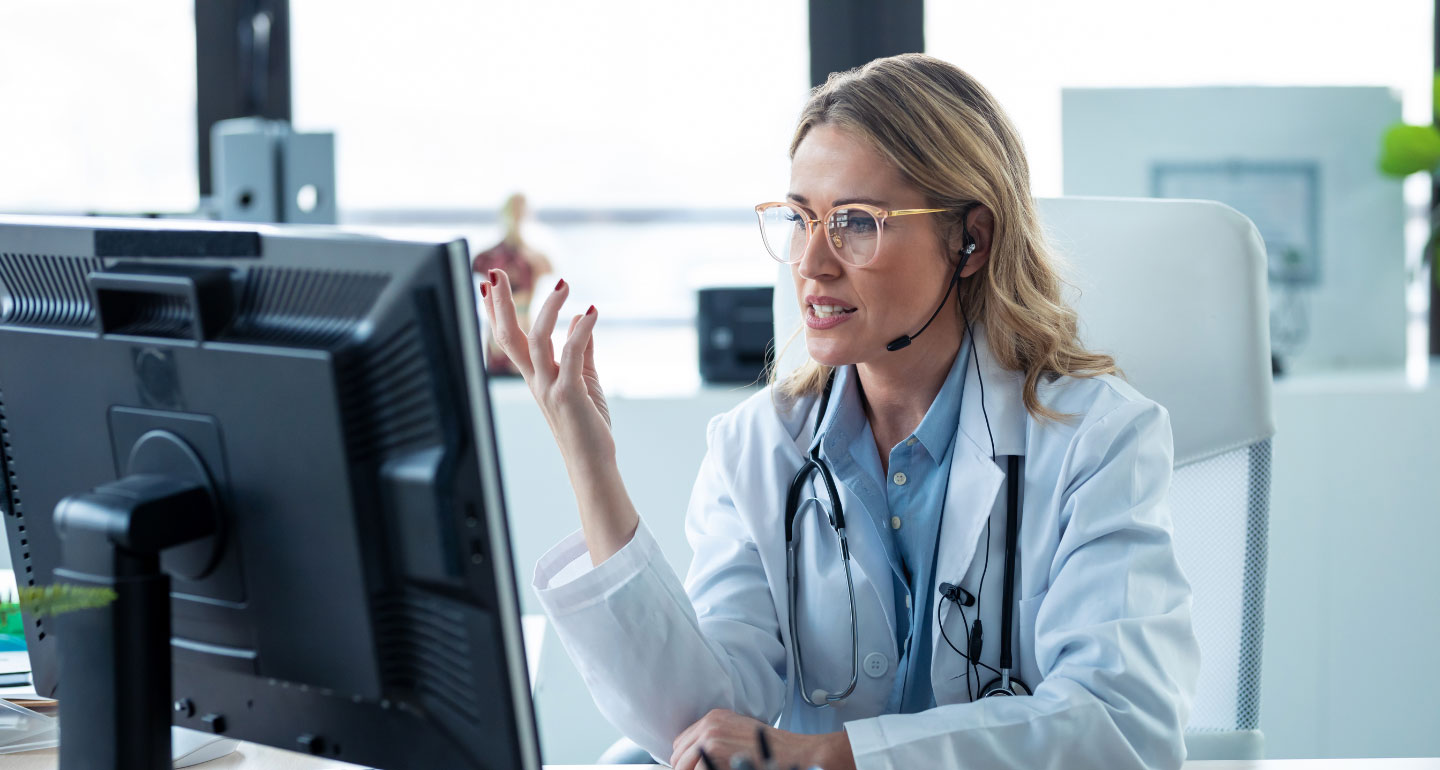 female medical professional with stethoscope at her computer engaged in a conversation online; Public Health program