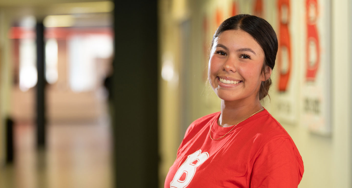 female Benedictine University secondary education student smiling in hallway