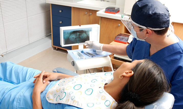 pre-dentistry, dentist with patient in chair looking at x-ray