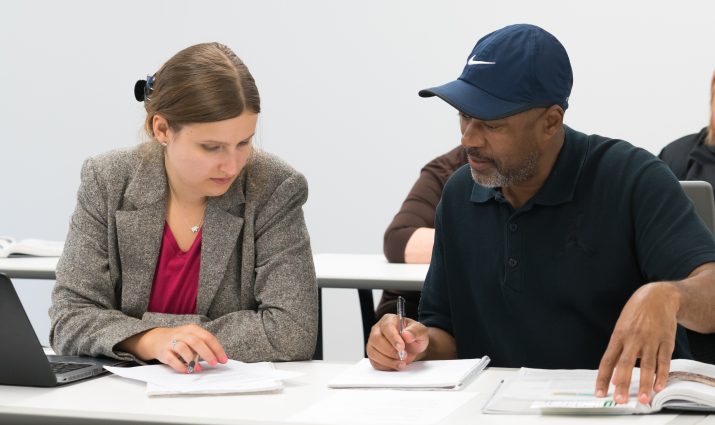 Adult students working together in a finance class