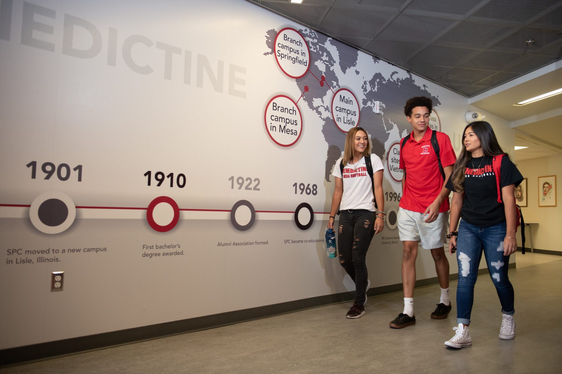 Male and female students walking through hallway, Mesa, campus