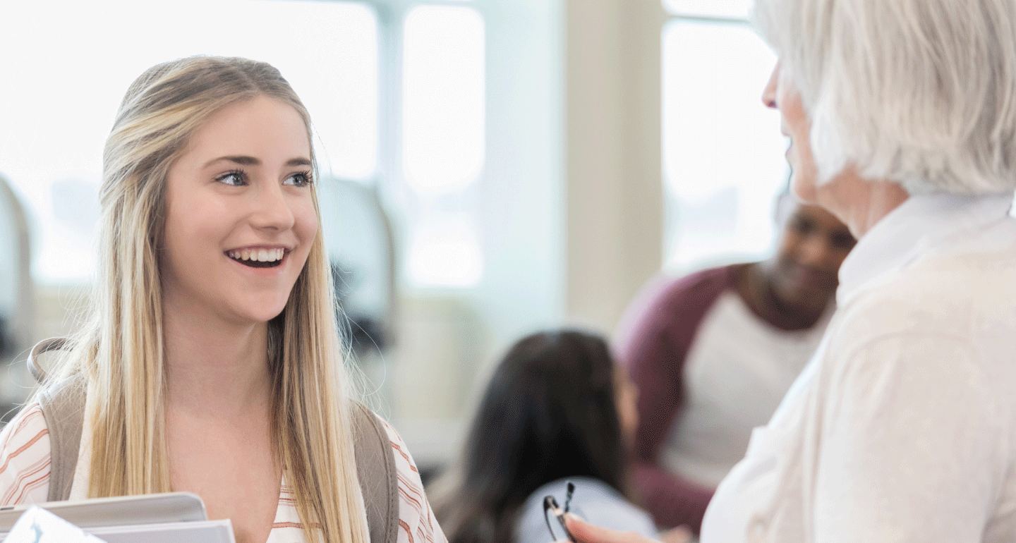 female student smiling at older female counselor; academic scholar award
