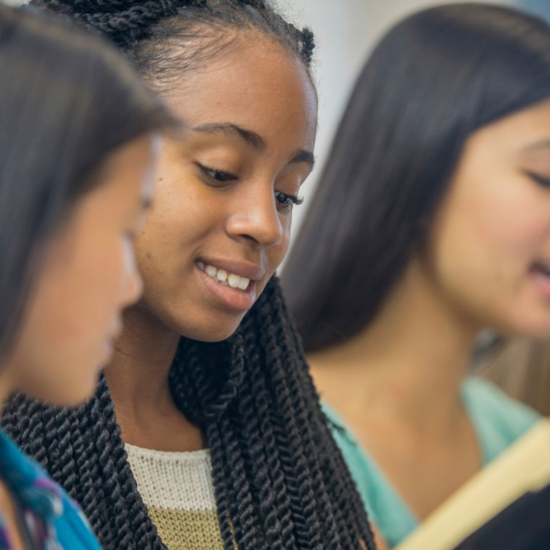 group of young women, one singing in the background while other look at book; Catholic high school award-Lisle