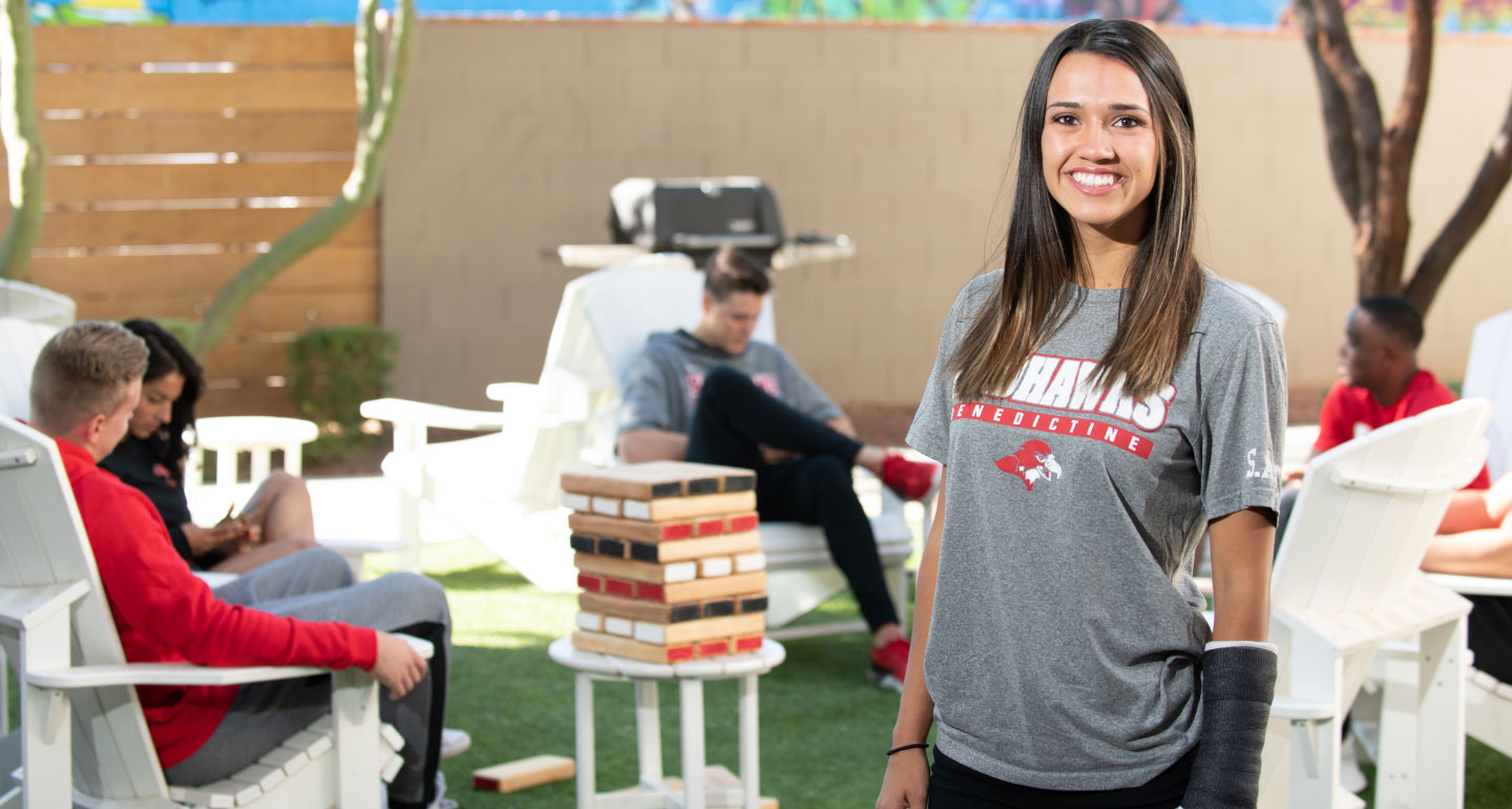 female Mesa student standing in front of a group of students reading in a circle; Jo Wilson Leadership Award