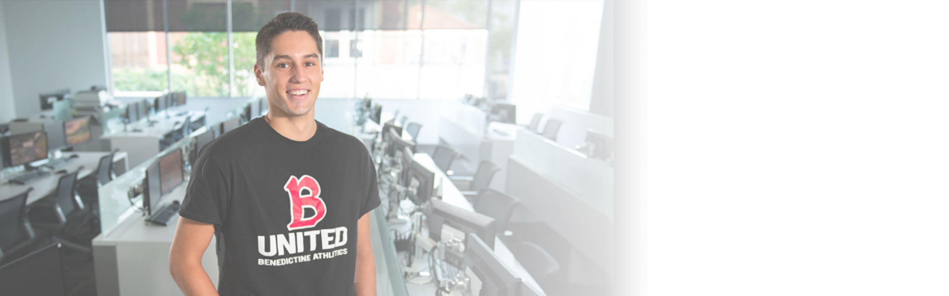 Undergraduate male student standing in the computer lab