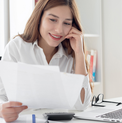 Female student leaning on her hand looking at paperwork; BenU Advising