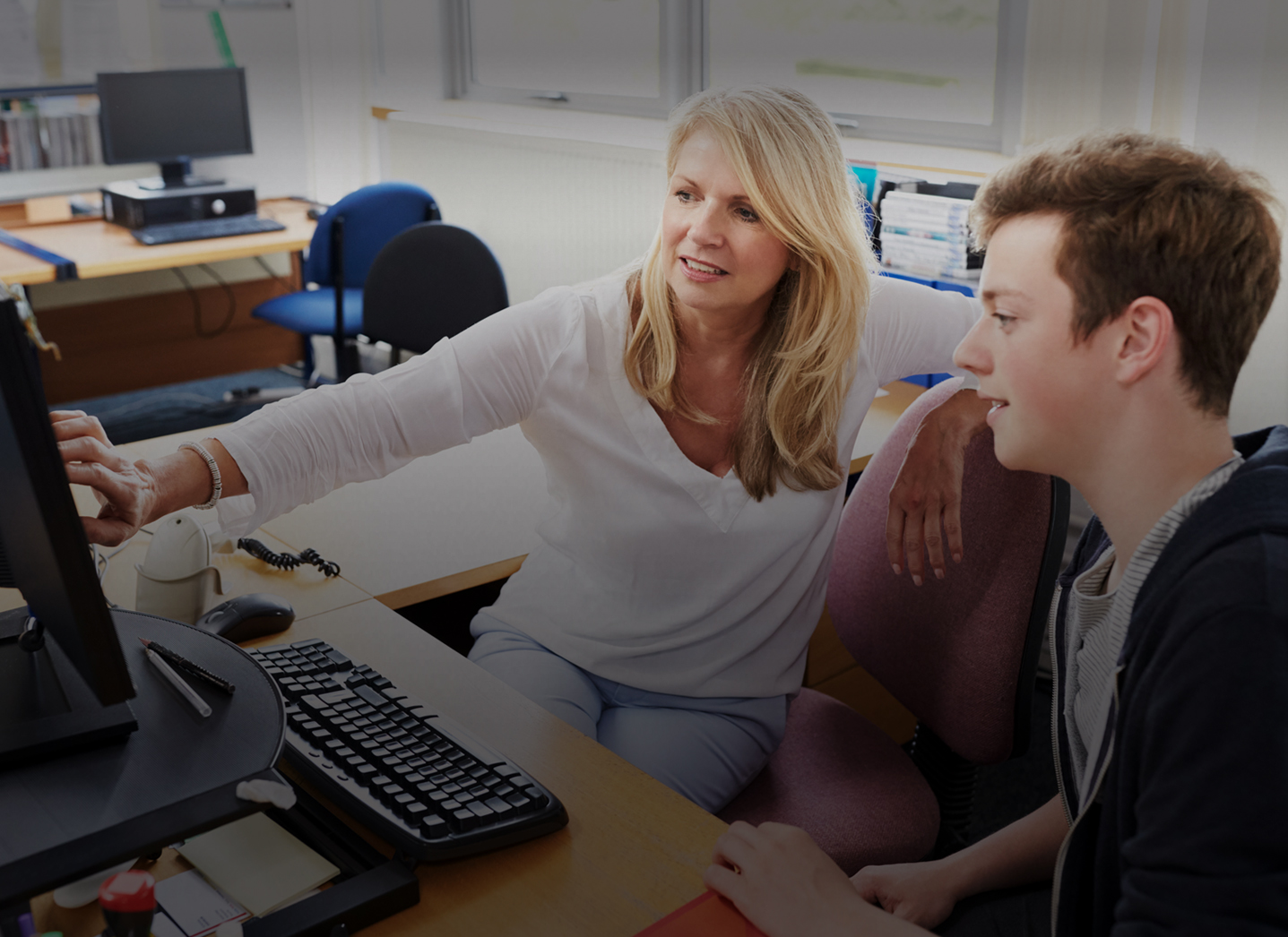 female instructor helping student, pointing to monitor; Advising center
