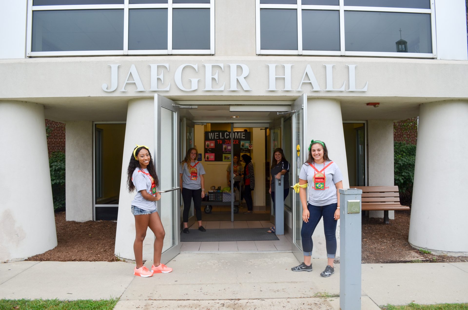 four female students holding the doors to Jaeger hall open on move in day