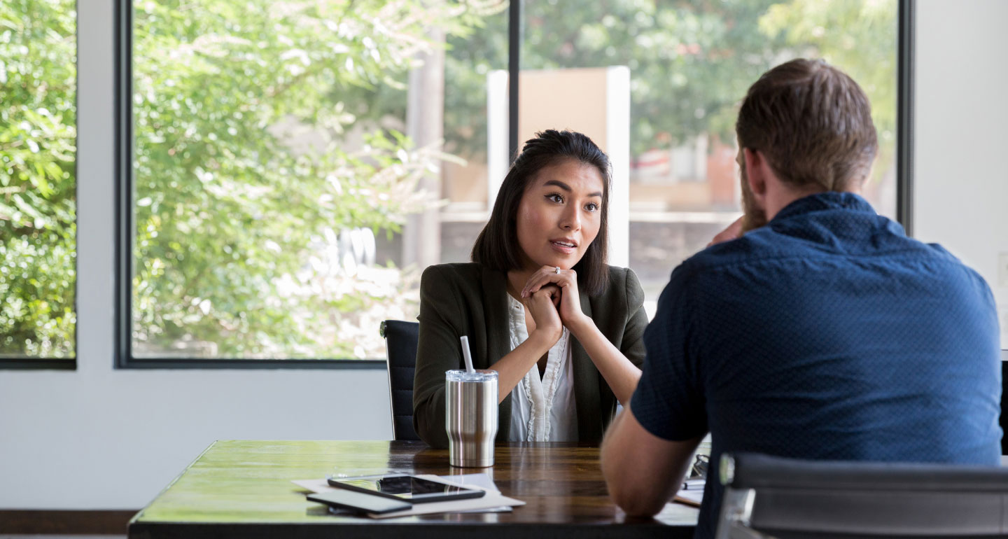 female counselor speaking with male student; CARE Team