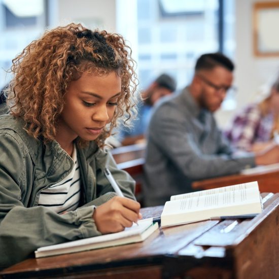 Female student sitting in class taking notes