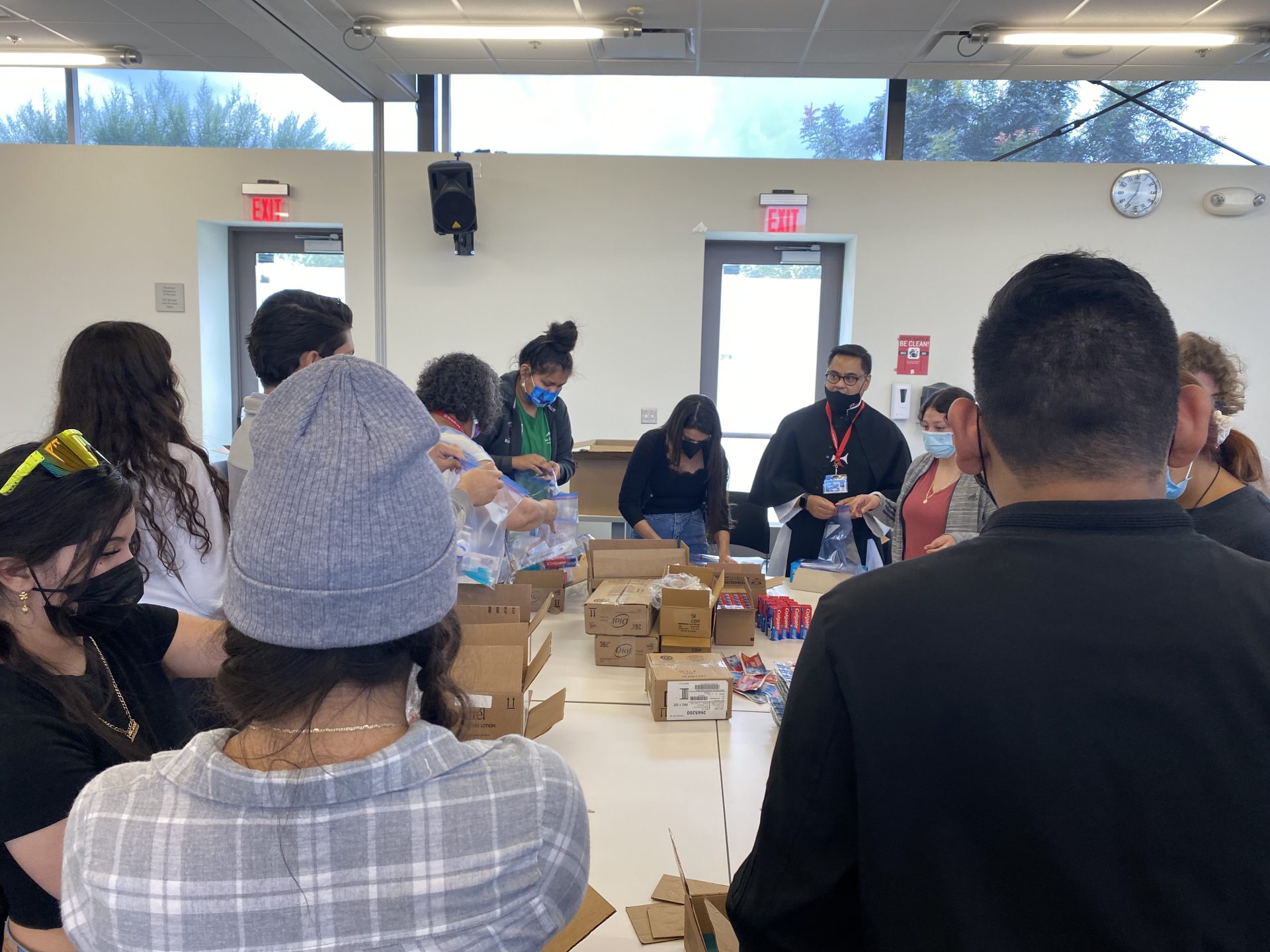 group of Mesa Campus Ministry students working together to put together care packages with "B"Involved group