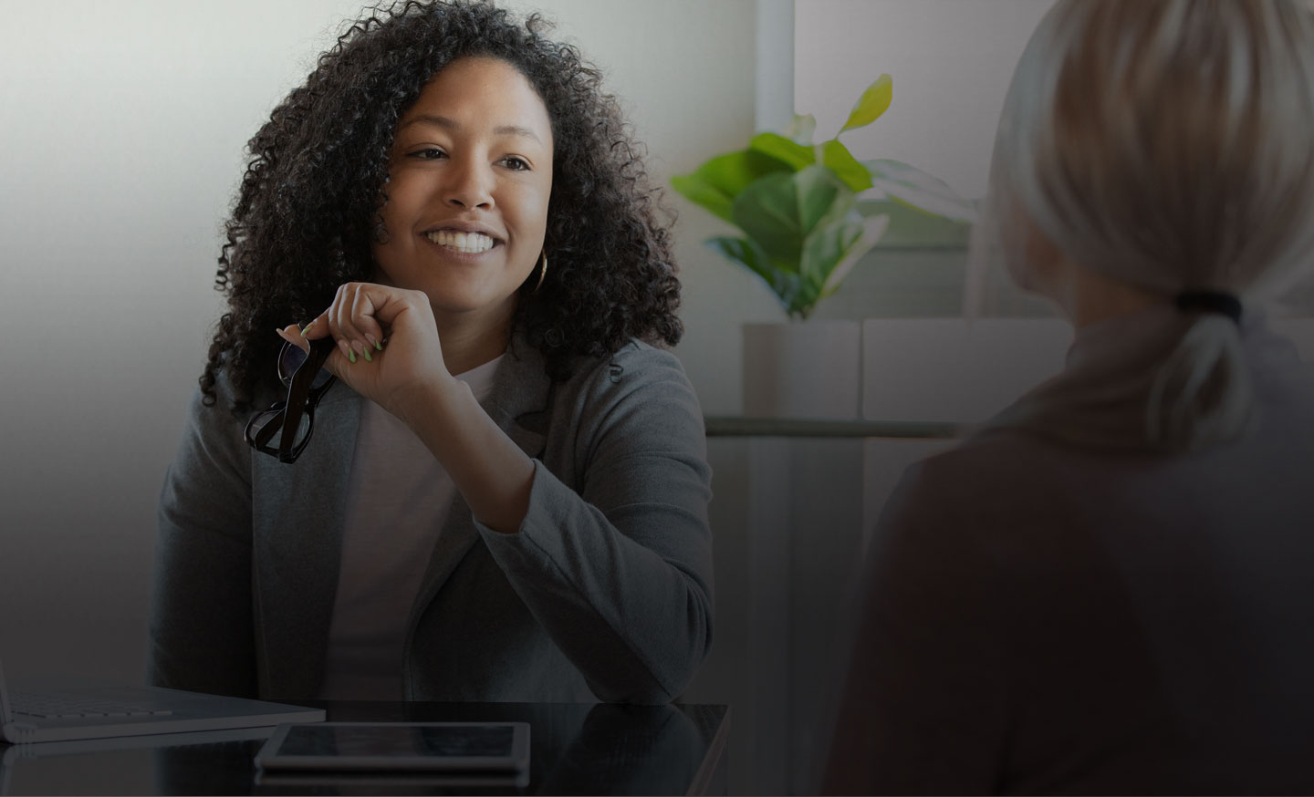 African American woman talking with another woman at table; parent and family engagement