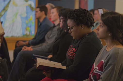 Student sitting in St. Benedict Chapel during mass