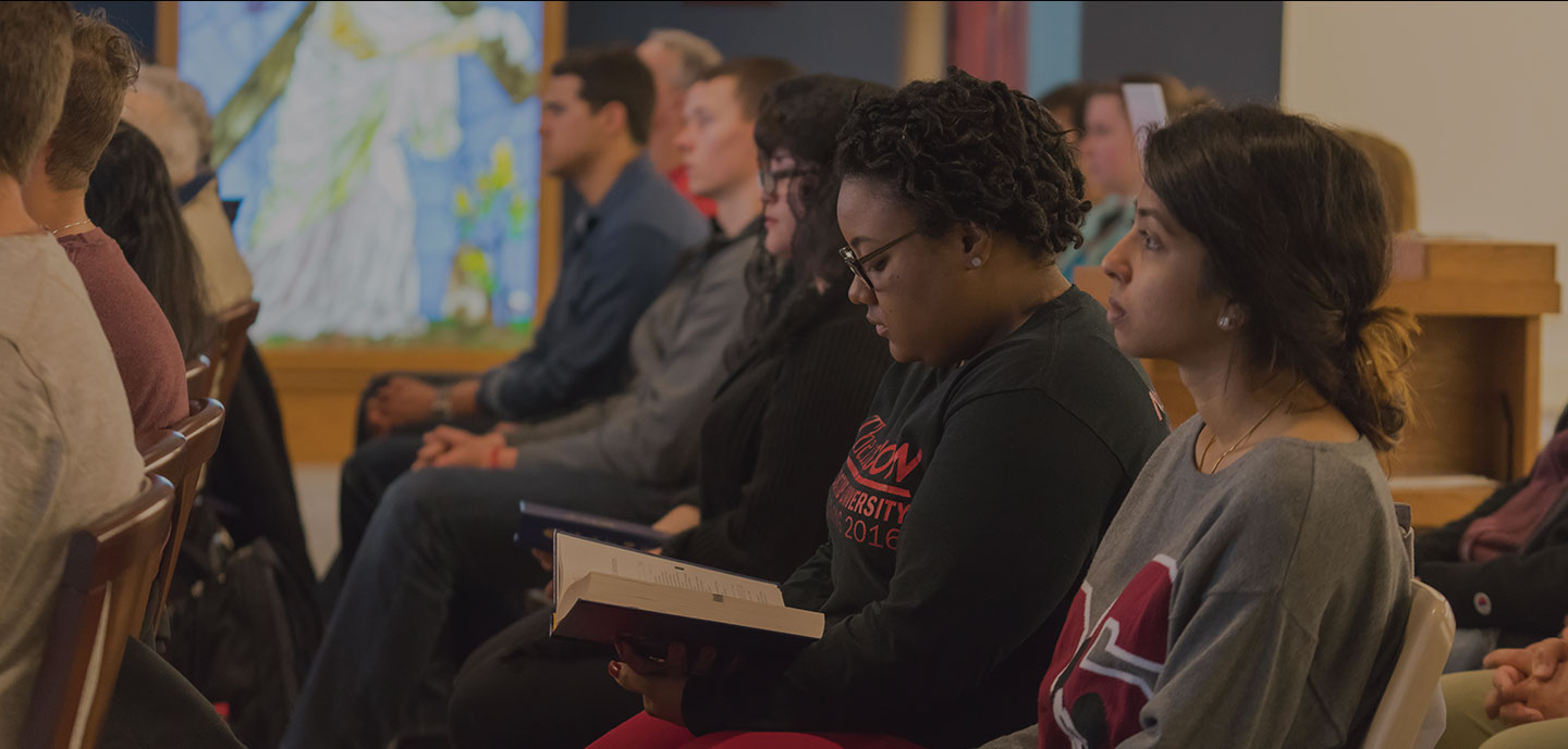 Student sitting in St. Benedict Chapel during mass