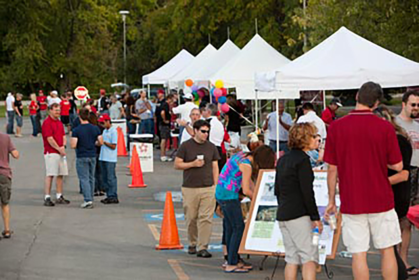 photo of college tents sent up at homecoming and faculty, stuff and guests enjoying the tailgating