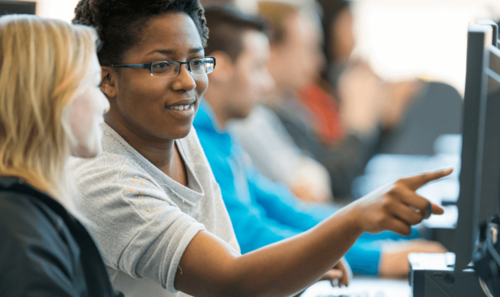 female student pointing to something on the computer - Global professional studies