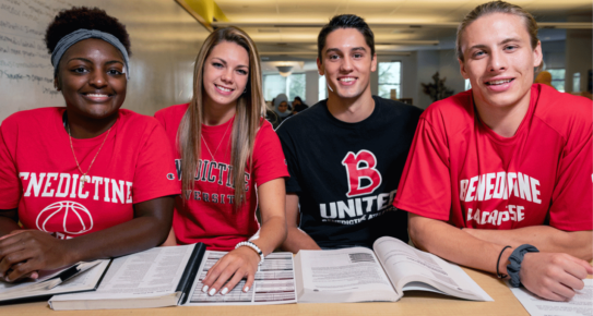 Degree programs. four Benedictine students smiling at camera while studying