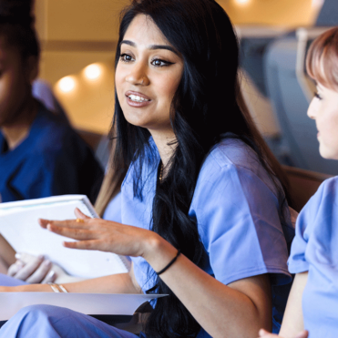 female Pre-professional students in scrubs in lecture setting
